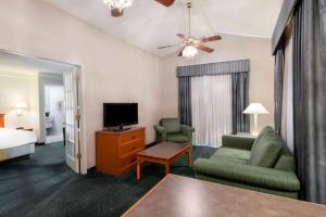 sala de estar con sofá, TV y cama en La Quinta Inn by Wyndham Farmington, en Farmington