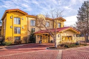 a yellow house with a red roof at La Quinta Inn by Wyndham Colorado Springs Garden of the Gods in Colorado Springs