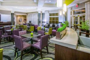 um átrio de um hotel com mesas e cadeiras em La Quinta by Wyndham St. Louis Westport em Saint Louis