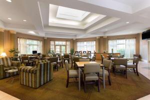 a dining room with tables and chairs and windows at La Quinta by Wyndham Jacksonville Butler Blvd in Jacksonville