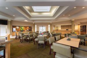 a restaurant with tables and chairs in a room at La Quinta by Wyndham Jacksonville Butler Blvd in Jacksonville