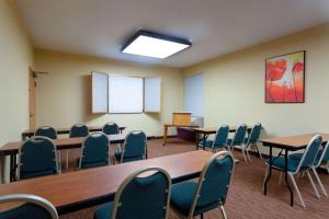 een kamer met tafels en stoelen in een klaslokaal bij La Quinta by Wyndham Charlotte Airport North in Charlotte