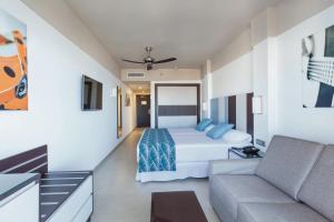 a bedroom with a bed and a couch at Hotel Riu Costa del Sol - All Inclusive in Torremolinos