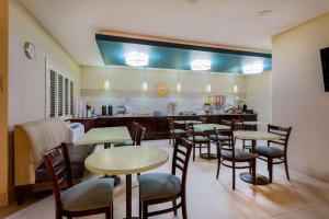 a restaurant with tables and chairs and a bar at Baymont by Wyndham Henderson-Northeast Denver in Henderson