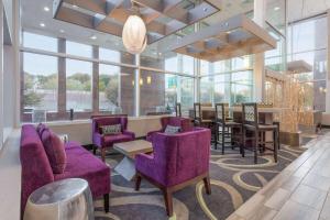een lobby met paarse stoelen, een tafel en ramen bij La Quinta by Wyndham Clifton/Rutherford in Clifton