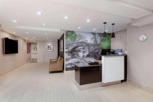 a lobby with a reception desk and a painting on the wall at La Quinta by Wyndham New York City Central Park in New York