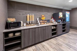 cocina con encimera, microondas y comida en La Quinta by Wyndham Anchorage Airport, en Anchorage