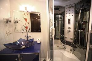 伊斯坦布尔卡通酒店的浴室设有水槽和带蓝伞的淋浴 更多46张照片