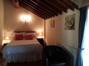 a bedroom with a bed with two red pillows at The Granary in Talgarth