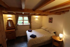 a small bedroom with a bed and a window at Bryngolau in Brechfa