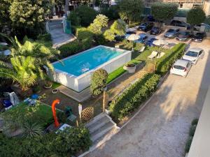 a garden area with a pool of water and lawn furniture at Hotel Costa Verde in Castiglioncello