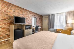 Habitación de hotel con cama y pared de ladrillo en Econo Lodge Middlesboro en Middlesboro