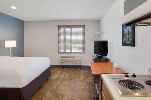 um quarto de hotel com uma cama e uma cozinha com um fogão em WoodSpring Suites Charlotte Shelby em Shelby