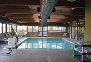 a large swimming pool in a building with windows at Comfort Inn and Suites Near Lake Guntersville in Scottsboro