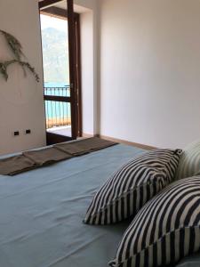a bed with two pillows in a room with a window at Al Porticciolo - Casa Vacanze in Marone