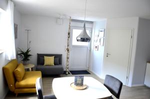 sala de estar con mesa y silla amarilla en Ferienwohnung Zaunkönig, en Beuren