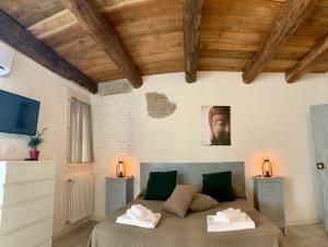a bedroom with a bed in a room with wooden ceilings at Green Rooms Ferrara in Ferrara