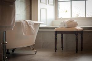 a bathroom with a tub and a chair and a window at Falls Hotel & Spa in Ennistymon