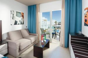 a living room with a couch and a table at Hotel Riu Costa del Sol - All Inclusive in Torremolinos