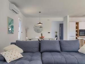 a living room with a blue couch and a table at Villa Vine by Interhome in Marčana