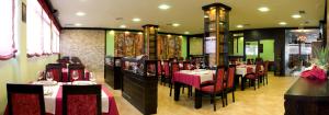 a dining room with tables and chairs in a restaurant at Hotel · Restaurante Asador Tio Manolo in Noya