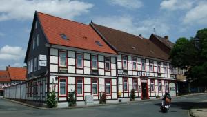 a black and white building with a red roof at Hotel Kniep in Bockenem