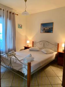 a bedroom with a large bed with white sheets at Ifigenia Apartments in Ermoupoli