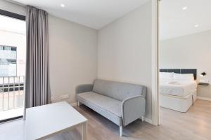 a bedroom with a bed and a chair and a table at Sitges Vibe Apartments by Olala Homes in Sitges