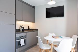 
a kitchen with a table and chairs and a refrigerator at Sitges Ocean View Apartments in Sitges
