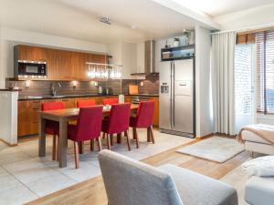 a kitchen with a wooden table and red chairs at Holiday Home Tahko spa suites orange b 1 by Interhome in Tahkovuori