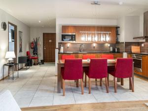 une cuisine avec une table en bois et des chaises rouges dans l'établissement Holiday Home Tahko spa suites orange b 1 by Interhome, à Tahkovuori