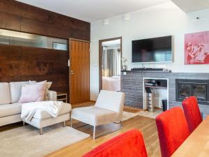 a living room with a couch and a fireplace at Holiday Home Tahko spa suites orange b 1 by Interhome in Tahkovuori