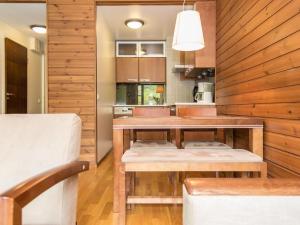 eine Küche mit Holzwänden und einem Tisch mit Bänken in der Unterkunft Holiday Home Ylläs chalets 2207 by Interhome in Ylläsjärvi + 9 Fotos