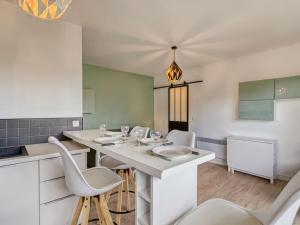 uma cozinha com uma mesa branca e cadeiras em Apartment Neptune by Interhome em Cabourg