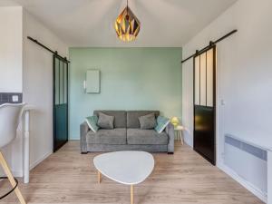 uma sala de estar com um sofá e uma mesa em Apartment Neptune by Interhome em Cabourg