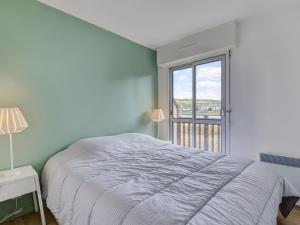 um quarto branco com uma cama e uma janela em Apartment Neptune by Interhome em Cabourg
