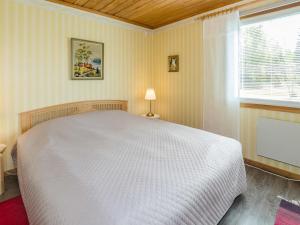 une chambre avec un lit blanc et une fenêtre dans l'établissement Holiday Home Purola by Interhome, à Polvijärvi