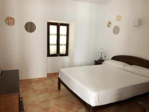 a bedroom with a white bed and a window at Can Font in Sineu