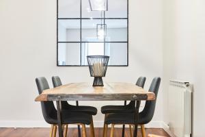 stół jadalny z czarnymi krzesłami i żyrandolem w obiekcie San Martin apartment by Basque Homes w mieście San Sebastián