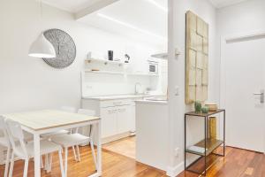 kuchnia z białymi szafkami, stołem i krzesłami w obiekcie San Martin apartment by Basque Homes w mieście San Sebastián +30 zdjęć