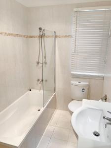 a bathroom with a shower and a toilet and a sink at City Center - Comfortable 2-Bedroom Apartment in Armidale