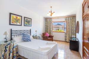 a bedroom with a bed and a chair and a window at Front Line Beach House Up To 6 Guests in Mallorca in Son Serra de Marina