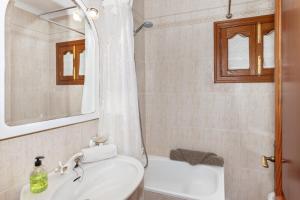 a white bathroom with a sink and a bath tub at Front Line Beach House Up To 6 Guests in Mallorca in Son Serra de Marina +25 photos