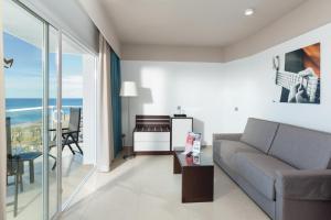 a living room with a couch and a table at Hotel Riu Costa del Sol - All Inclusive in Torremolinos