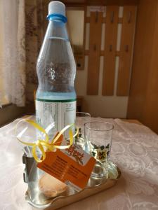 a bottle of water and two glasses on a table at Pension Ufert in Meißen