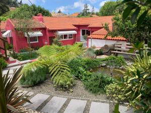 a garden in front of a red house at Storytellers Villas in Sintra