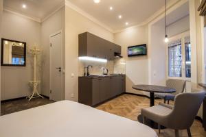 a room with a bed and a table and a kitchen at Idea Design Apart-Hotel Maidan in Kyiv