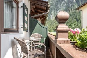 a balcony with chairs and a table and a window at Appartements Mair in Mayrhofen