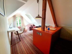 an attic room with an orange counter and a living room at Hartnoll Hotel & Spa in Tiverton