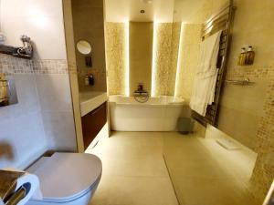 ein Badezimmer mit einer Badewanne, einem WC und einem Waschbecken in der Unterkunft Hartnoll Hotel & Spa in Tiverton